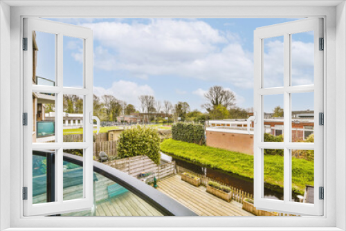 Fototapeta Naklejka Na Ścianę Okno 3D - a balcony with green roofing and grass on the lawn in front of the house, as seen from an apartment window