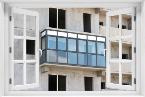 Fototapeta Naklejka Na Ścianę Okno 3D - One glazed balcony in an unfinished block high-rise building.