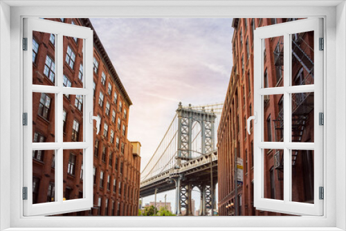 Fototapeta Naklejka Na Ścianę Okno 3D - Manhattan Bridge between Manhattan and Brooklyn over East River seen from a narrow alley enclosed by two brick buildings on a sunny day, New York City
