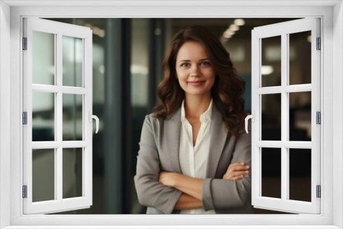 happy businesswoman at office with arms crossed