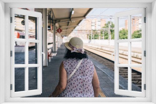 Retired woman on the train platform to start her vacation. Older lady walking to the train for leisure trip.