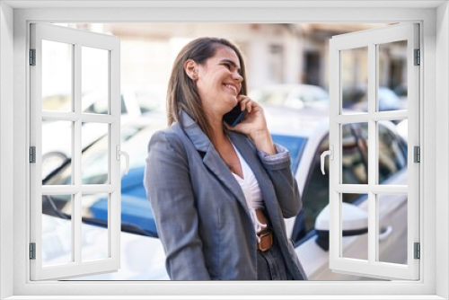 Young woman smiling confident talking on the smartphone at street