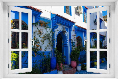 Fototapeta Naklejka Na Ścianę Okno 3D - An arched doorway in a building with shades of blue and flowerpots