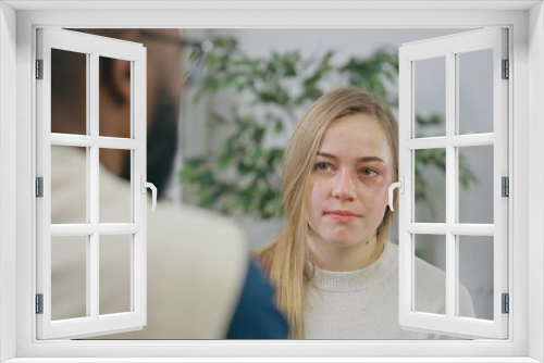 Sad young woman talking to psychologist at therapy session, depression treatment