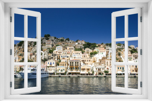 Colorful houses lining the harbor at Symi, Greece