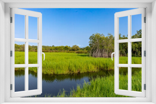 Fototapeta Naklejka Na Ścianę Okno 3D - An enchanting scene of a rural landscape, with a beautiful field, a tranquil lake and a clear blue sky, inviting a sense of relaxation and serenity.