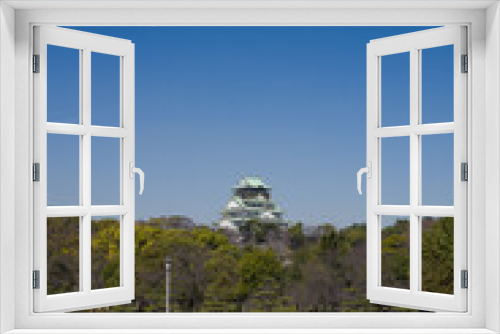 Fototapeta Naklejka Na Ścianę Okno 3D - Scenic view of Osaka castle with trees and clear blur sky