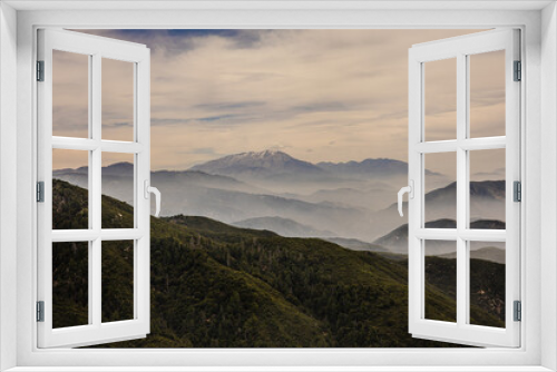 Fototapeta Naklejka Na Ścianę Okno 3D - Clouds rolling into the mountains with a green forest