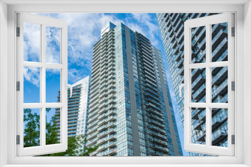 Fototapeta Naklejka Na Ścianę Okno 3D - New block of modern apartments with balconies and blue sky in the background. View of an apartment complex in Surrey BC