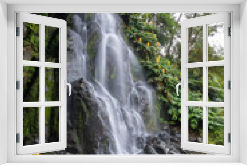 Fototapeta Naklejka Na Ścianę Okno 3D - Waterfall in the Botanical Garden of Ribeira do Guilherme in Nordeste with tourists, Sao Miguel island in the Azores.