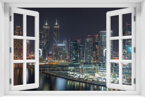 Fototapeta Naklejka Na Ścianę Okno 3D - Cityscape with skyscrapers of Dubai Business Bay and water canal aerial night timelapse.