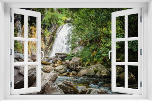 Fototapeta Naklejka Na Ścianę Okno 3D - Korbu Waterfall is located on one of shores of Lake Teletskoye, Altai Republic, Siberia, Russia. Spring landscape, beautiful waterfall surrounded by trees and rocks, tourism place, nature environment
