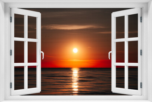 Fototapeta Naklejka Na Ścianę Okno 3D - Rays Of Rising Sun Create Golden Sheen On The Water Surface Of Ocean, As If Ocean Becomes Crystal And Noble. Sunrise On Beach Symbolizes Beginning Of New Day, Hope And Awakening Of Nature To Life.