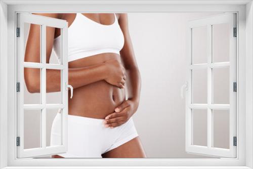 Hands, body and stomach of a woman for health and wellness on white background in studio. Fitness, gut and diet of person in underwear for weight loss, care or digestion and fertility with space