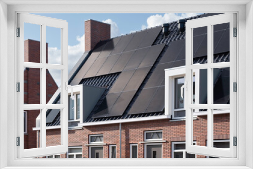 Fototapeta Naklejka Na Ścianę Okno 3D - Solar panels mounted on the roofs of a row modern new-build social rental houses in Lemmer, Friesland, the Netherlands with blue sky