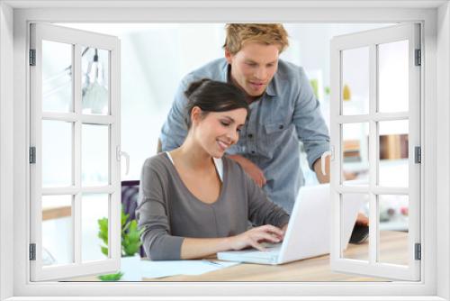 Young people in office working on laptop