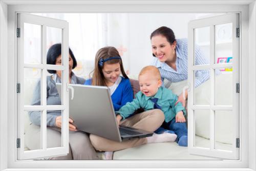 Grandmother, mother, daughter and son using laptop at home.