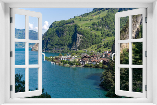 Fototapeta Naklejka Na Ścianę Okno 3D - Scenic aerial view of Lake Lucerne with Swiss village Sisikon mountain panorama seen from lakeshore on a sunny spring day. Photo taken May 22nd, 2023, Lake Uri, Switzerland.