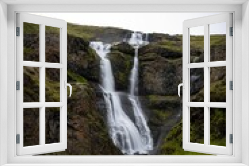 Fototapeta Naklejka Na Ścianę Okno 3D - Vibrant Rjukandi waterfall cascading down a lush green hillside