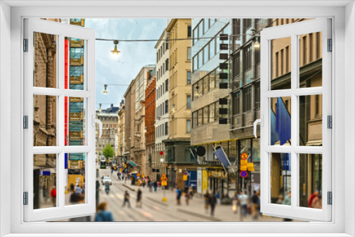 Fototapeta Naklejka Na Ścianę Okno 3D - Street of Helsinki, commercial buildings at evening with lots of pedestrians and tourists walking around and looking sights. Nice street lighting. Good detailed tourism photo