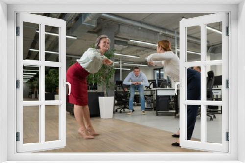 Four office workers warm up during a break. Employees do fitness exercises at the workplace. 