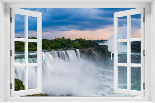 Fototapeta Naklejka Na Ścianę Okno 3D - A panoramic long exposure photo of the American - Canadian waterfalls Niagara Falls in cloudy dusk.
