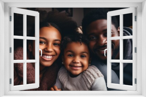 picture of a happy young African American family with little children sitting lounging on the sofa, cuddling lying down,