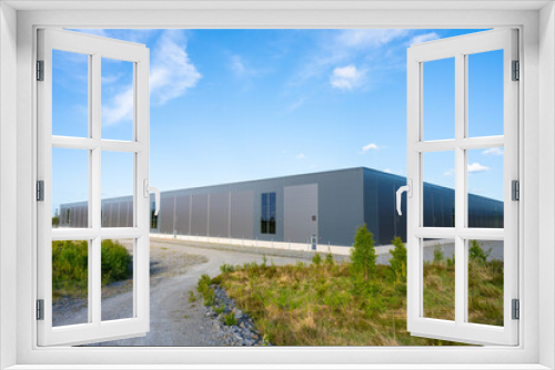 Fototapeta Naklejka Na Ścianę Okno 3D - Exterior of a new and large grey warehouse.
