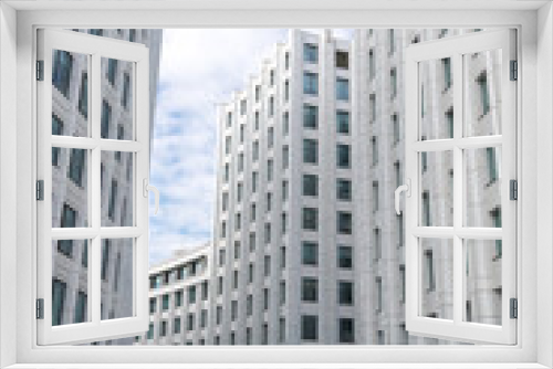 Fototapeta Naklejka Na Ścianę Okno 3D - Side view of empty pedestrian street between tall white buildings. Blue sky with some clouds. Copy space for your text or decoration. Urban architecture theme.