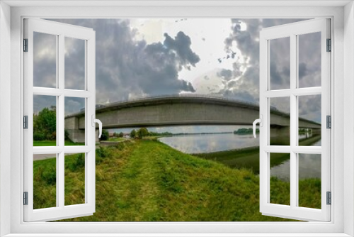 Fototapeta Naklejka Na Ścianę Okno 3D - Panoramic landscape of a bridge over a lake in the green field
