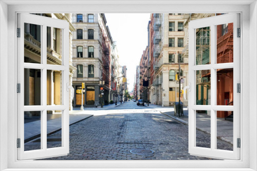 Fototapeta Naklejka Na Ścianę Okno 3D - Empty streets and sidewalks of Soho are eerily quiet during the 2020 coronavirus pandemic lockdown in New York City with no people and sunset background