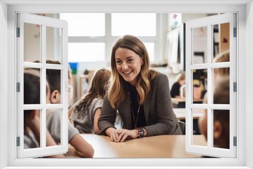 Portrait of smiling teacher sitting at desk with her students in classroom