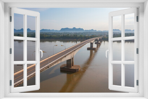 Fototapeta Naklejka Na Ścianę Okno 3D - Aerial view of Thai Laos bridge with Mekong River with green mountain hill. Nature landscape background in Ubon Ratchathani, Thailand.