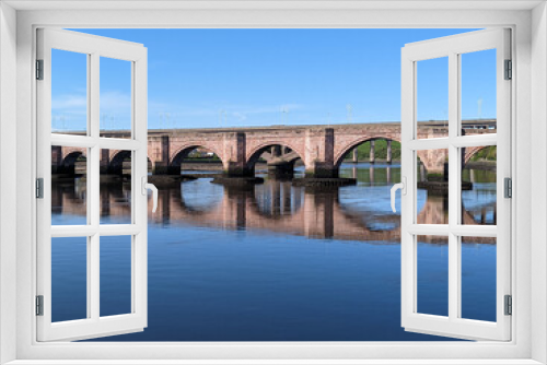 A view upstream along the River Tweed towards the ancient bridge at Berwick-upon-Tweed in Northumberland, England, UK.