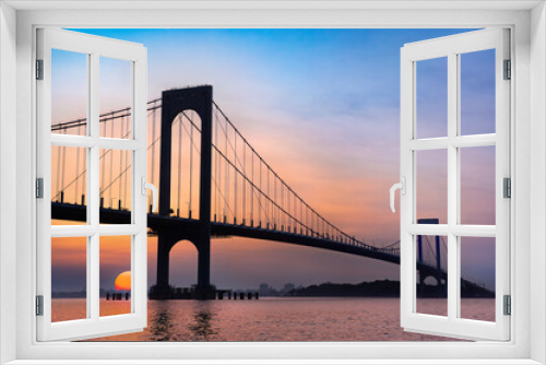 Fototapeta Naklejka Na Ścianę Okno 3D - View of the Whitestone Bridge in Queens, New York City at sunset with the water of the Long Island Sound in view.