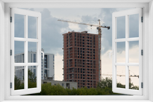 Fototapeta Naklejka Na Ścianę Okno 3D - Construction of new residential buildings: construction site with crane and construction equipment