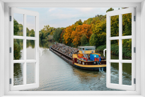 Fototapeta Naklejka Na Ścianę Okno 3D - Transportation industry. Ship barge transports scrap metal and sand with gravel. Barge loaded with scrap metal is on the roadstead. Scrap metal transportation by water. Barge laden by metal salvage