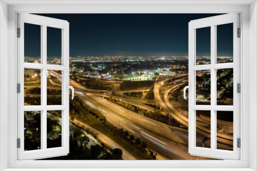 Fototapeta Naklejka Na Ścianę Okno 3D - Aerial view of american freeway intersection at night with fast driving cars and trucks in Miami, Florida. View from above of USA transportation infrastructure