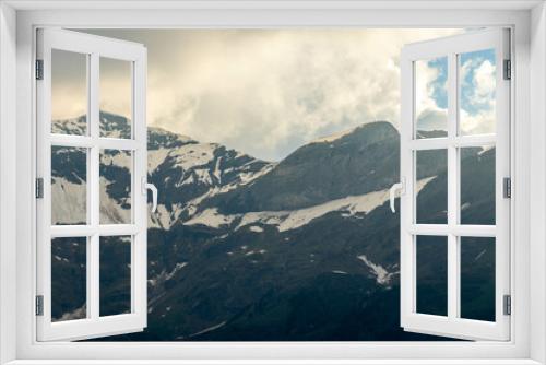 Fototapeta Naklejka Na Ścianę Okno 3D - Close Ups of Mountains of the Swiss Alps in Switzerland in the Summer at Sunset with the Mountains Peaking Through Clouds