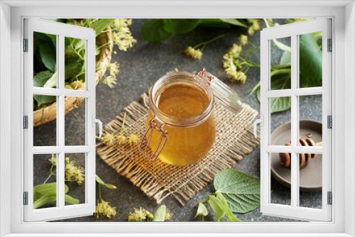 Fototapeta Naklejka Na Ścianę Okno 3D - A jar of honey with a wooden dipper and fresh linden blossoms