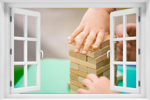 Fototapeta Naklejka Na Ścianę Okno 3D - close-up of a child's hand playing wood blocks stack game