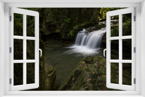 Fototapeta Naklejka Na Ścianę Okno 3D - A small waterfall between stones in the forest.