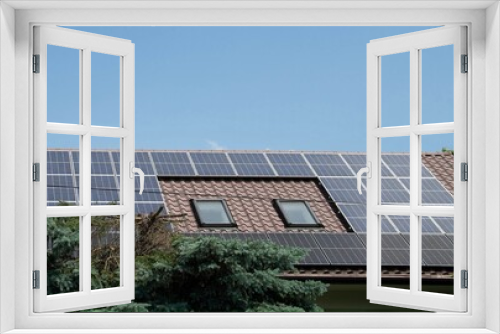 Fototapeta Naklejka Na Ścianę Okno 3D - Installing a Solar Cell on a Roof. Solar panels on roof. Historic farm house with modern solar panels on roof and wall. High quality photo