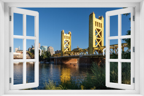 Fototapeta Naklejka Na Ścianę Okno 3D - Photo of the golden Tower Bridge over the Sacramento River. The bridge is the western downtown entry point to the city of Sacramento, capital of California.