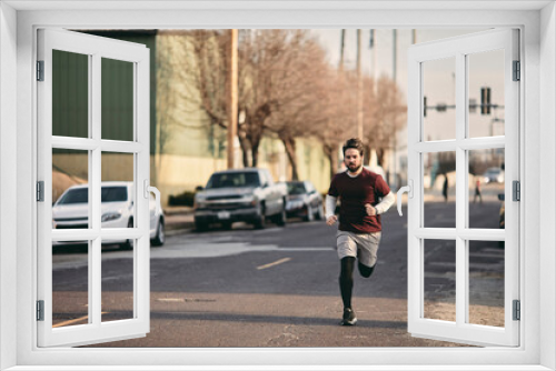 Young man running on a empty road in the city