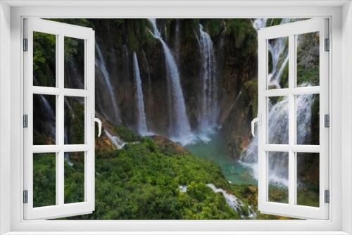 Fototapeta Naklejka Na Ścianę Okno 3D - Waterfalls in green mountain forest landscape with streams of water. Cascades flow among lush greenery in spring or summer.
