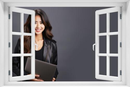 Smiling Asian businesswoman holding laptop computer