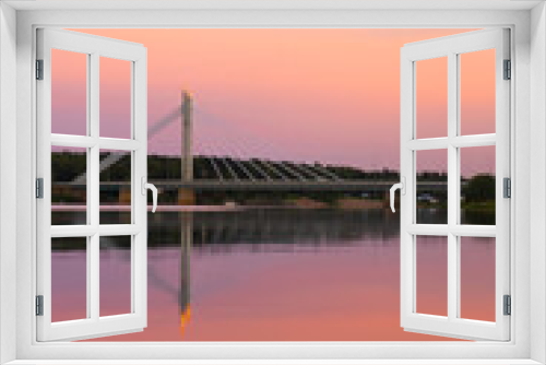 Fototapeta Naklejka Na Ścianę Okno 3D - Vertical photo. An Lovely sunset in Rovaniemi Finland. Polar day. Traveling to Lapland. Pink sky over the bridge. Vacation in the north. Reflection in the water. Color gradient. Fantastic Scandinavia