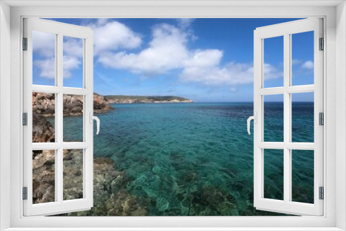 Fototapeta Naklejka Na Ścianę Okno 3D - Picturesque sandy beach with crystal-clear blue waters and rocky shoreline in  Ibiza