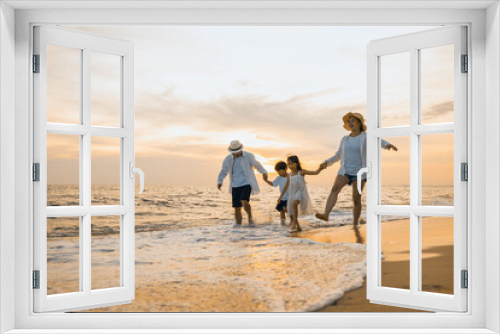 Fototapeta Naklejka Na Ścianę Okno 3D - Happy family having fun running on a sandy beach at sunset time, Active parents and people father, mother, children son and daughter holding hands together walking on beach, tropical summer vacations